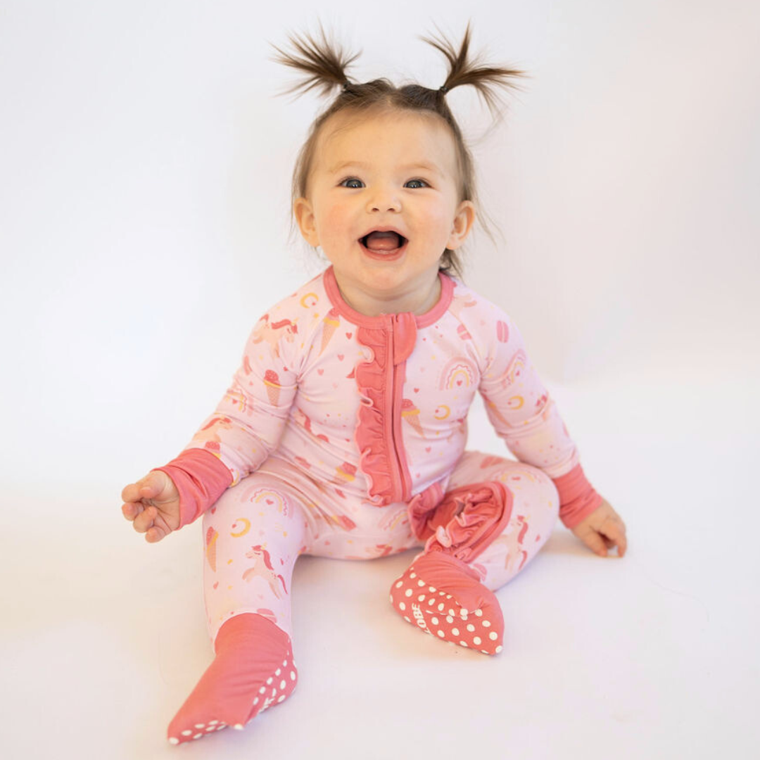 Baby wearing bamboo convertible zipper pajamas in pink sweet dreams design